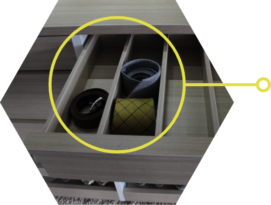 Detail of an open divided drawer with neatly rolled ties